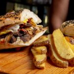 Delicious Cheeseburger and Baked Potatoes on Wooden Chopping Board