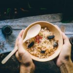 person holding bowl filled with food
