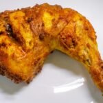 Golden-brown Pollo Campero-style fried chicken leg quarter with crispy skin and savory seasoning, showcasing Latin American flavor and texture.