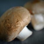 Close-up of fresh cremini mushrooms on a dark surface, highlighting their smooth caps and stems—ideal for showcasing homemade Longhorn stuffed mushroom preparation.