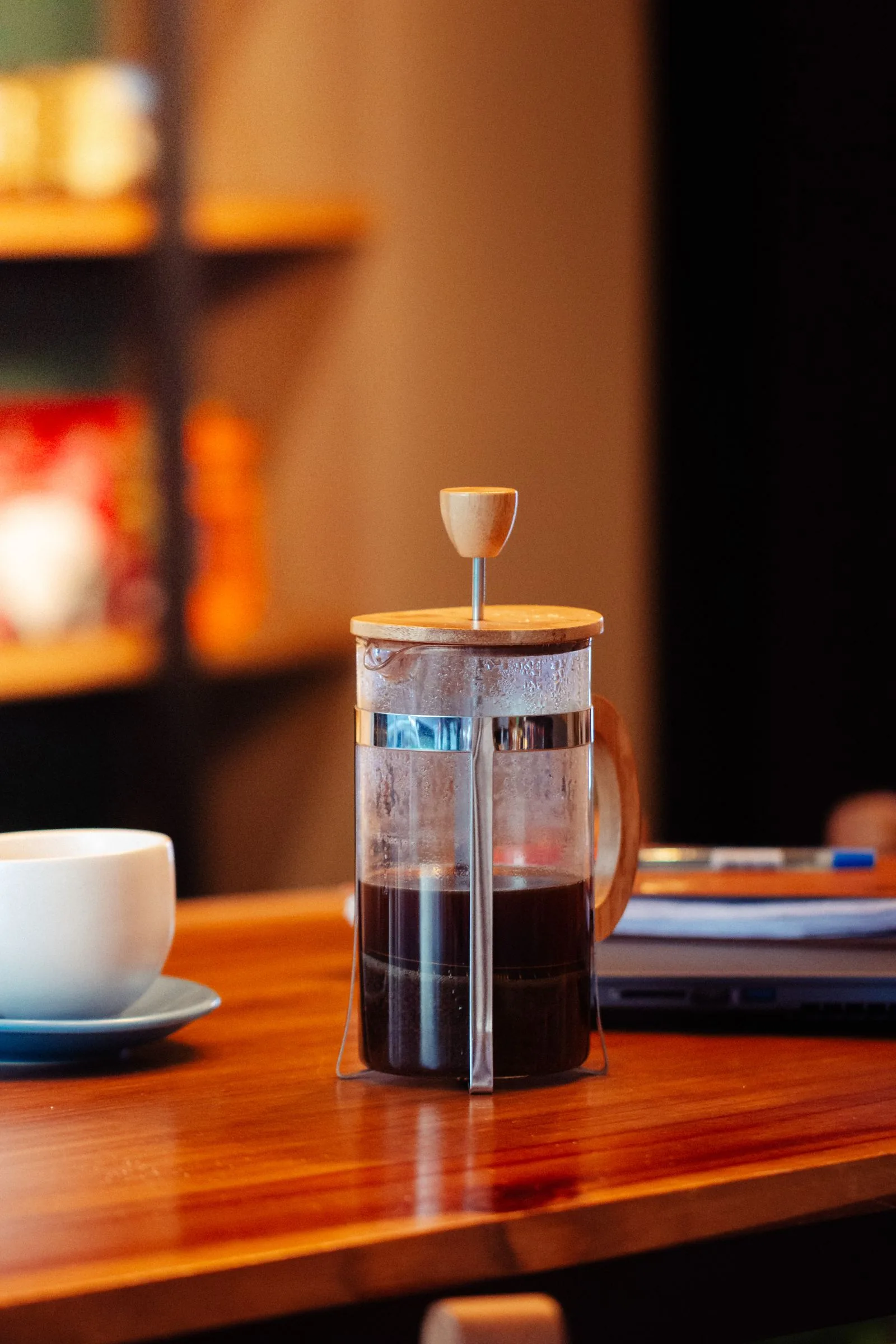 French press filled with brewed coffee on a wooden table
