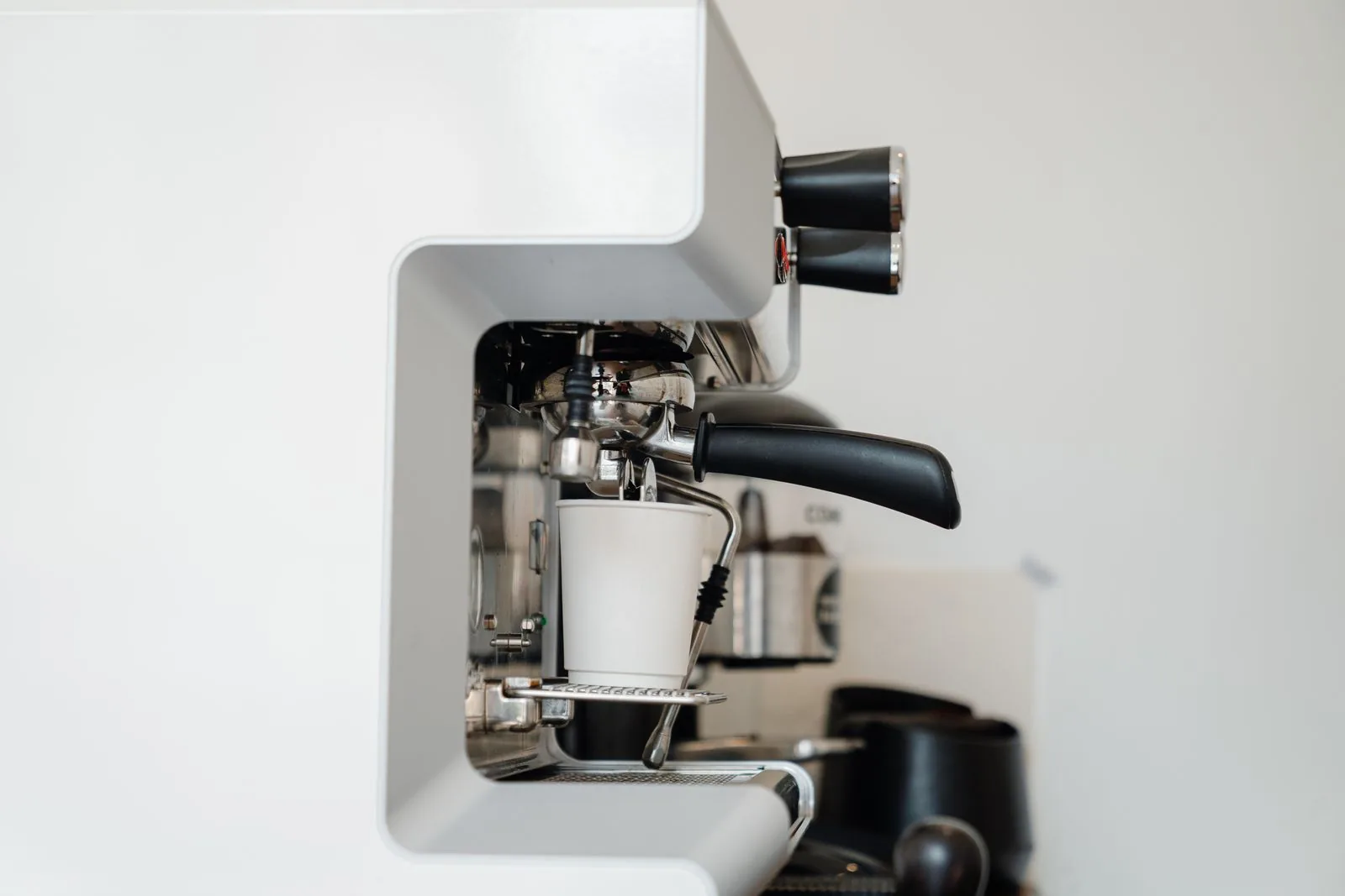 Espresso machine brewing a fresh cup of coffee in a minimalist home kitchen